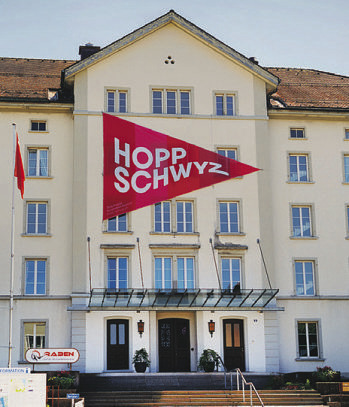 Seit vergangenen Dienstag ziert ein riesiger «Hopp Schwyz» -Wimpel  die Fassade des Kulturzentrums  Zwei Raben
